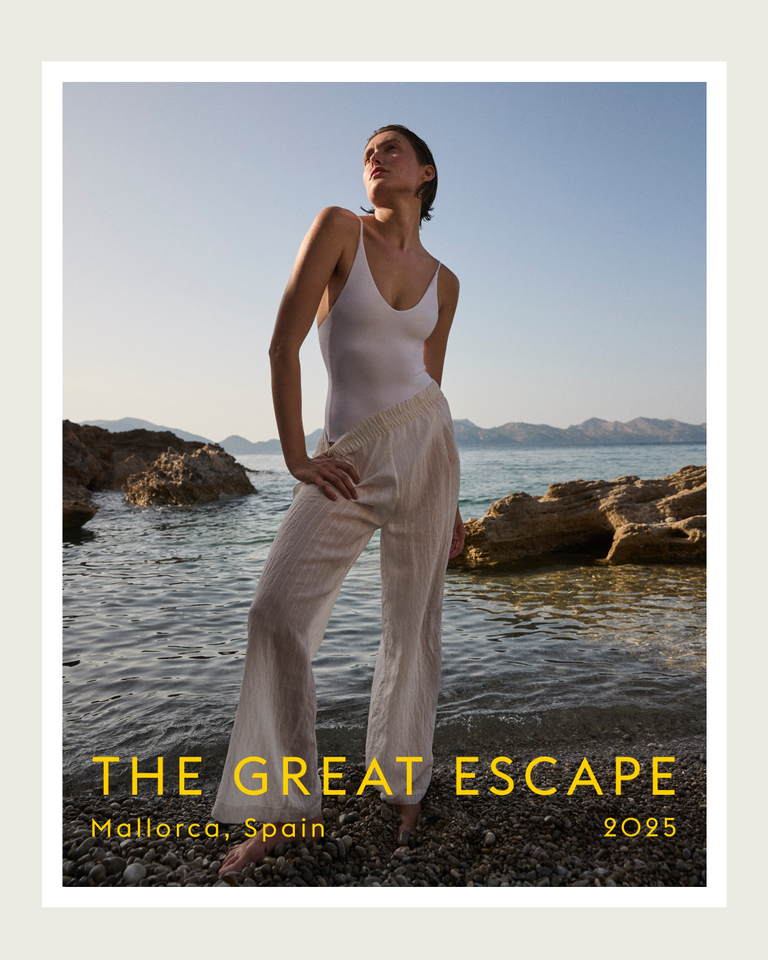 Woman in a white outfit standing by the water with 'The Great Escape' text overlay