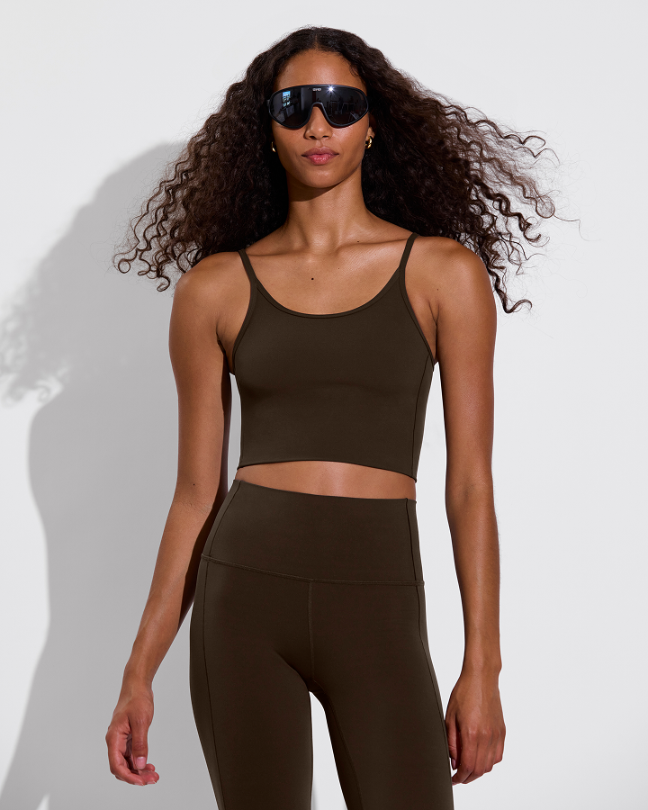 Woman in Barre tank and super moves tight in cold brew