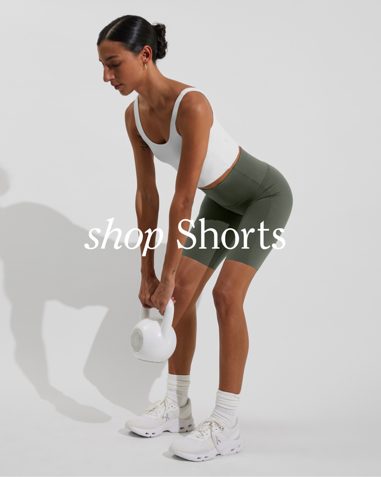 Woman in Super Moves Short 5" in agave paired with reset tank in coconut