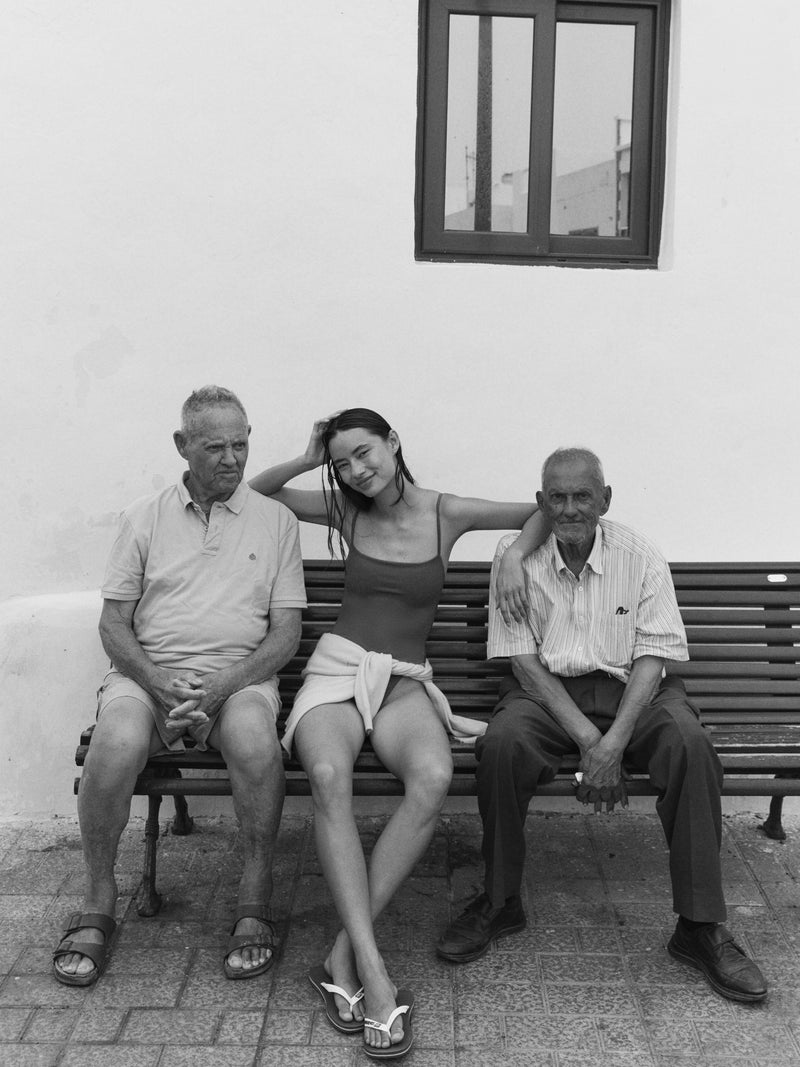 Left On Friday one piece modelled sitting on a bench with two men