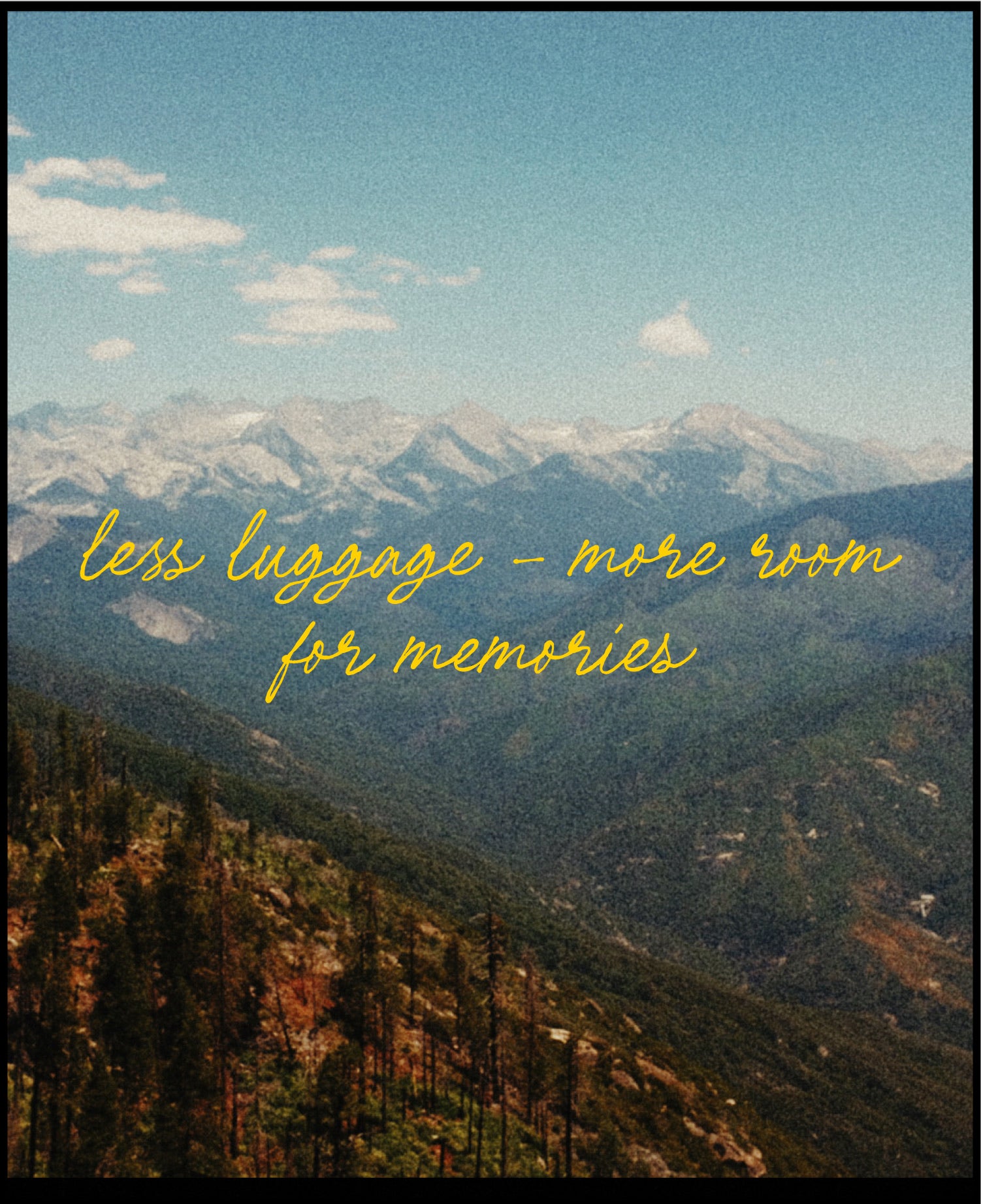 A scenic mountain landscape with layered blue-gray peaks, snowy tops, forested slopes, and a pale blue sky. Yellow script text across the center reads, 'less luggage - more room for memories.