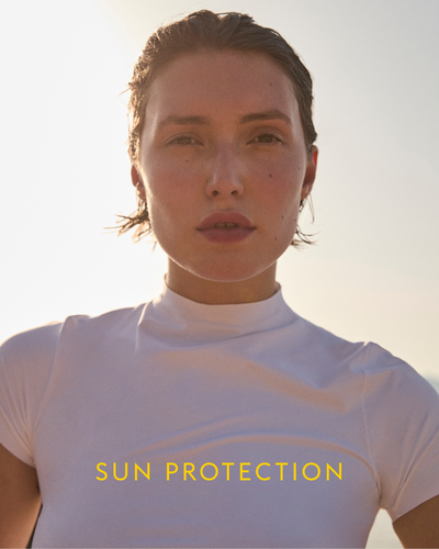 Person wearing a white Rays Short Sleeve Top with 'Sun Protection' text against a bright background